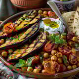 A plate of grilled aubergines with tomatoes and mint.