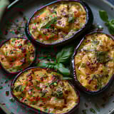A plate of four aubergines with herbs on top.