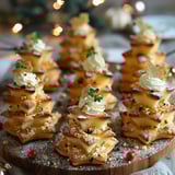 A plate of miniature Christmas trees with whipped cream and herbs on top.
