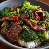 A bowl of beef and broccoli with a hoisin sauce.