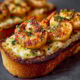 A piece of bread with shrimp on top.