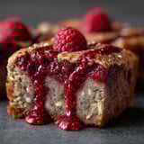 A slice of cake with raspberries on top.