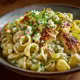 A bowl of pasta with chicken and cheese.